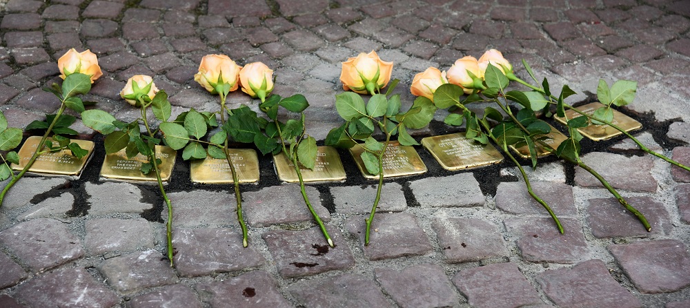 Acht frisch verlegte Stolpersteine mit Rosen bei der Stolpersteinverlegung 2017