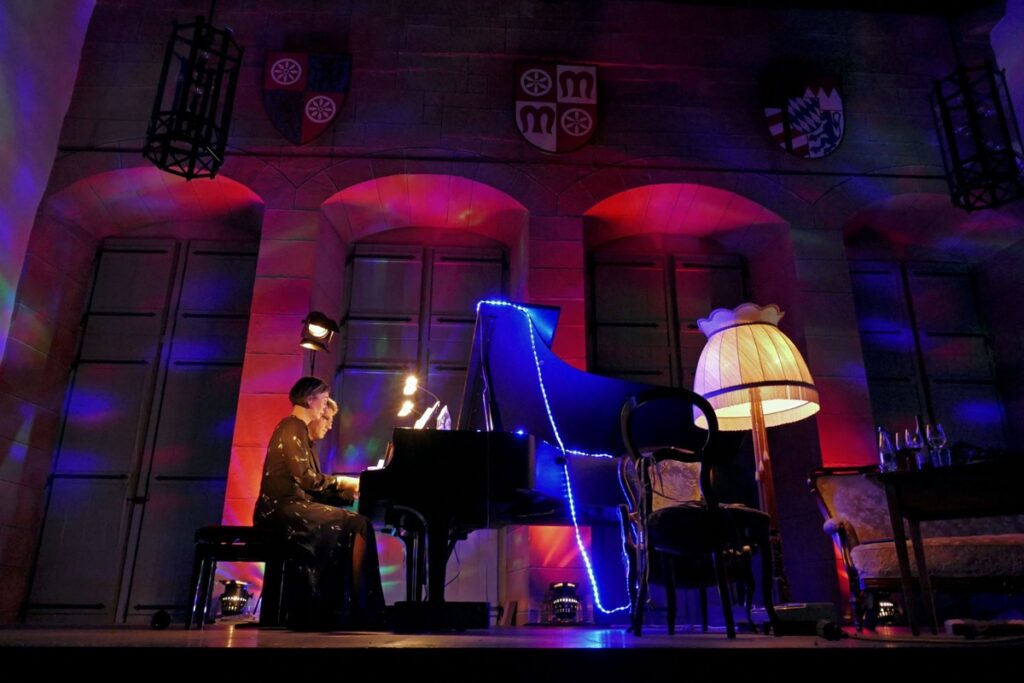 Sylvia Ackermann vom Claviersalon Miltenberg spielt auf dem Flügel im Alten Rathaus bei stimmungsvoll gedämpftem Licht