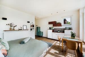 Mainterrasse Panorama Apartments - Apartment MainZeit Bett mit Blick Richtung Küchenzeile