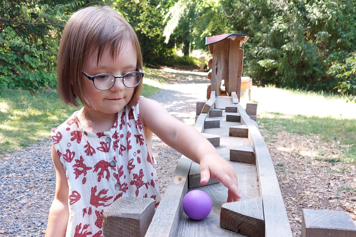 Ein Kind spielt mit der Holzkugelbahn im Stadtpark in Miltenberg