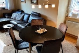 Esstisch und im Hintergrund Sofa in der Ferienwohnung Kaufmann in Miltenberg