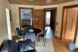 Esstisch und im Vordergrund Sofa in der Ferienwohnung Kaufmann in Miltenberg