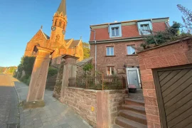 Das Haus mit der Ferienwohnung Mauersegler in Miltenberg mit der benachbarten evangelischen Kirche
