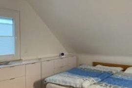 Doppelbett und Sideboard im Schlafzimmer der Ferienwohnung Liane Schneider in Miltenberg