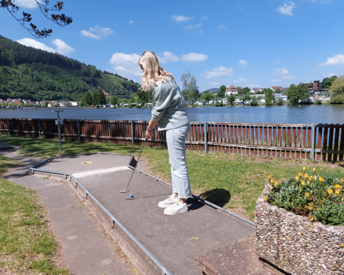 Frau spielt Minigolf auf dem Minigolfplatz am Main in Miltenberg